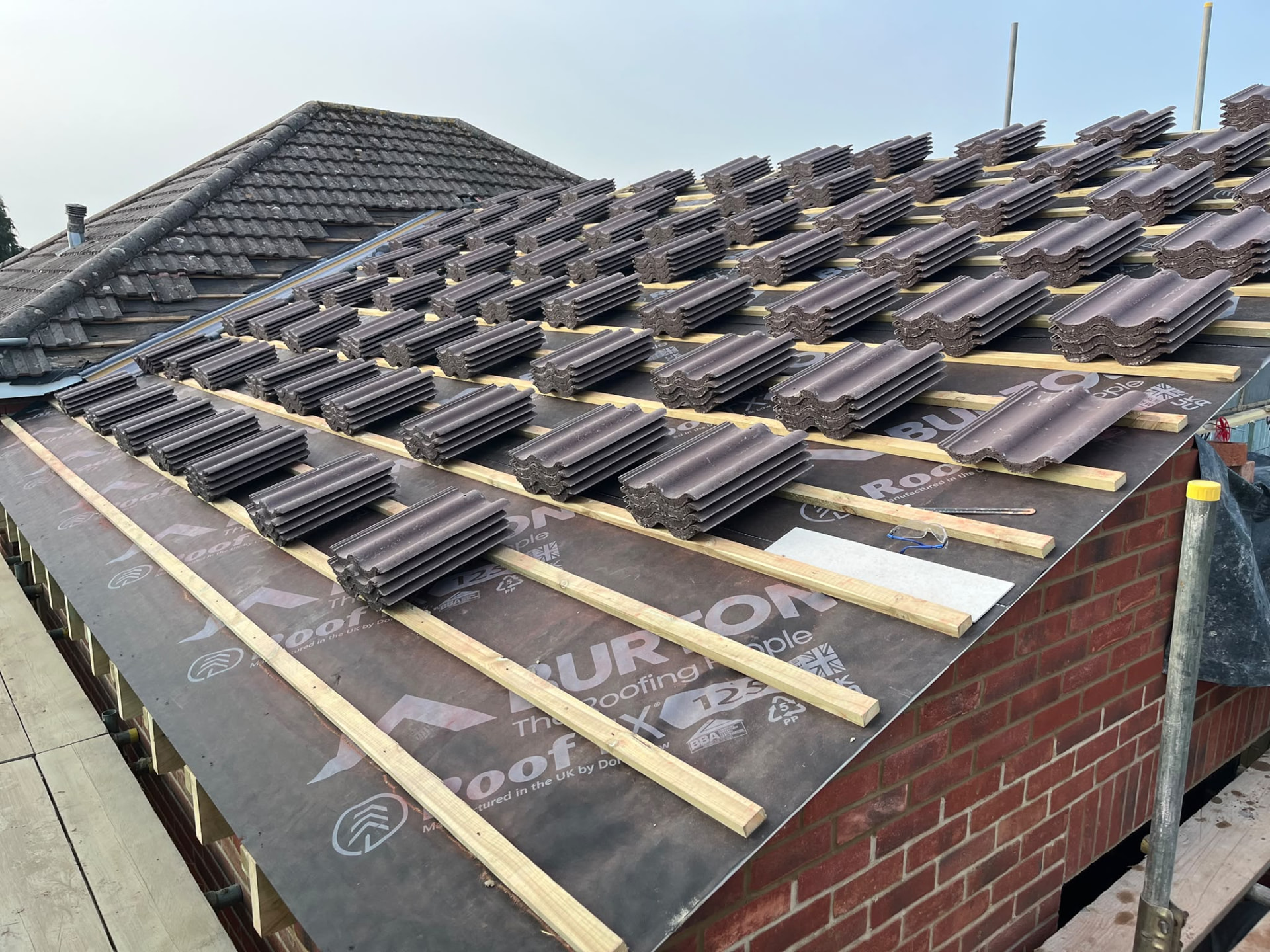 New roof felted and battened with tiles loaded out during a BMS rebuild